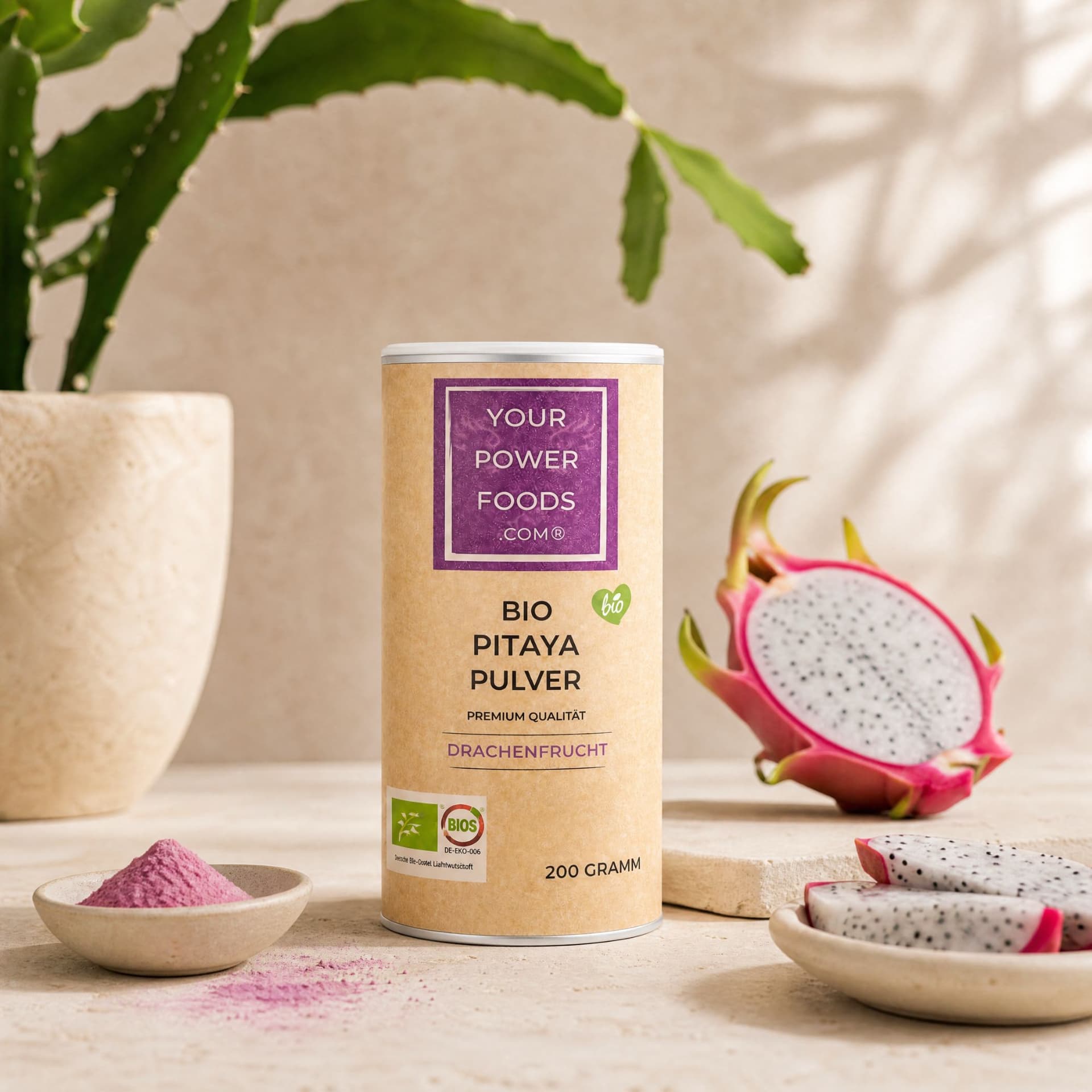 Pitaya Pulver Bio 200g in Kraftpapier-Dose, Lifestyle-Szene mit frischer Drachenfrucht und rosa Pulver in Schälchen