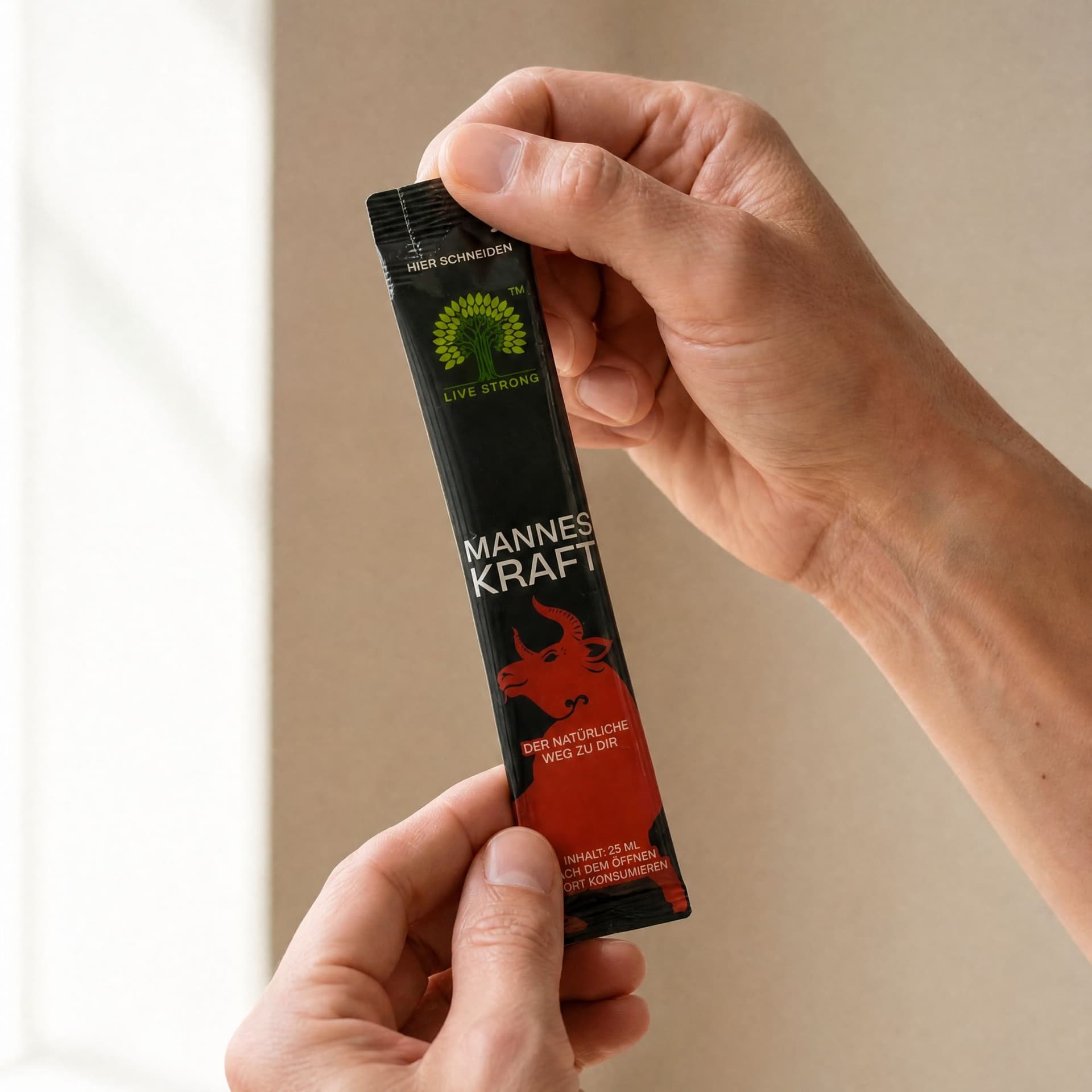 Manneskraft.com | Original | Libido Boost – dvije ruke drže crnu vrećicu od 25 ml neposredno prije otvaranja