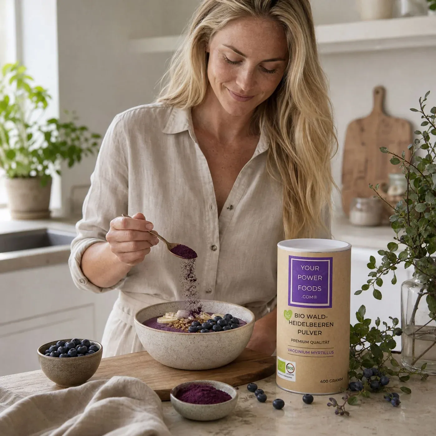 Bio Waldheidelbeeren Pulver, Premium Qualität, 400g – Lifestyle-Szene: Frau streut lila Pulver in einen Smoothie-Bowl mit Bla
