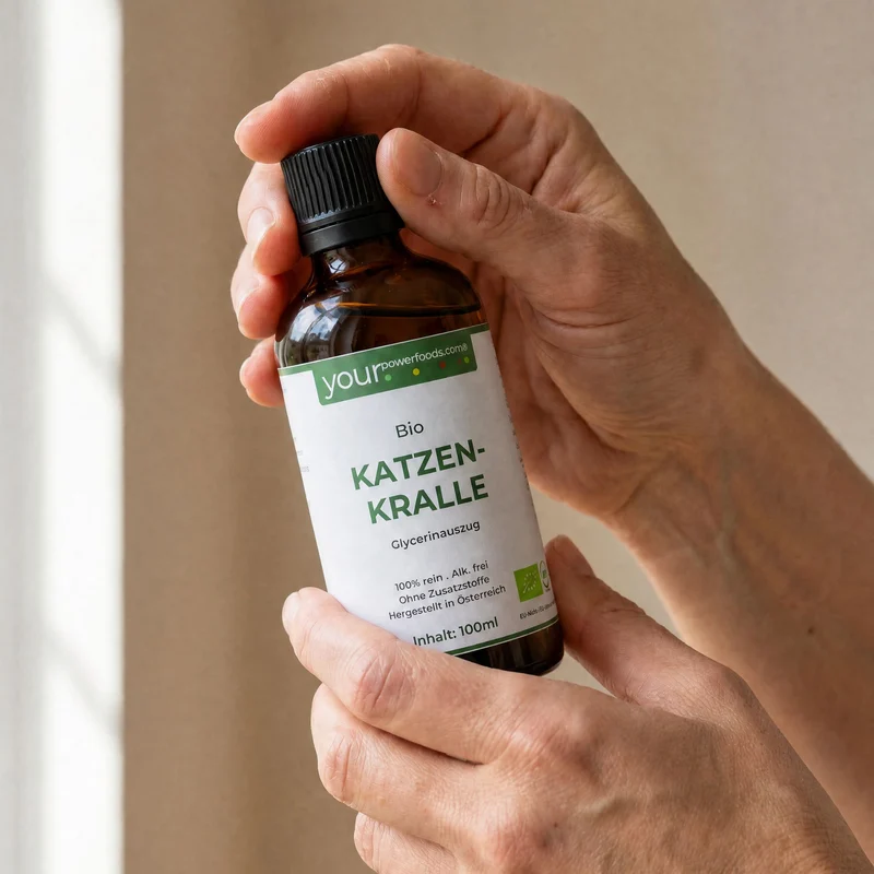 Katzenkralle flüssig alkoholfrei Cat's Claw 100ml – zwei Hände halten braune Tropfflasche mit grünem Etikett