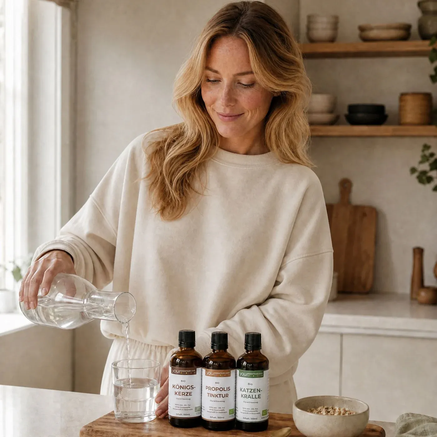 Immun Balance Bundle – Königskerze, Katzenkralle & Propolis: Frau gießt Wasser in Glas, daneben drei braune Tropfflaschen auf