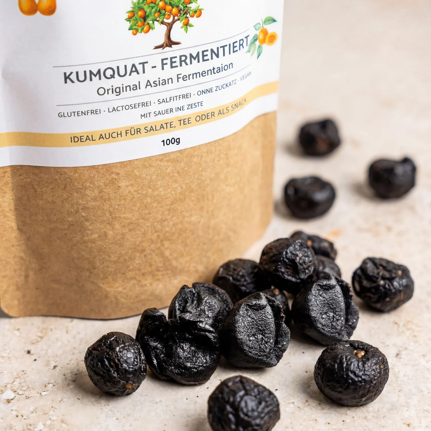 Fermentirani kumkvat 100g premium kvalitete – vrećica od kraftpapira s etiketom i crni fermentirani kumkvati na svijetloj podlozi